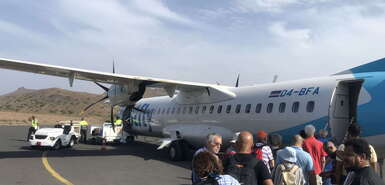 Bestfly-Maschine mit Touristen und Einheimischen davor