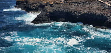 Blaues Meer und dunkle Felsen