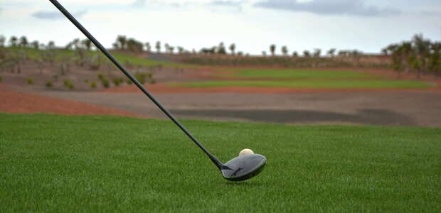 Golfschläger und Golfball auf dem grünen Rasen