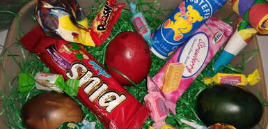 Osternest mit bunten Eiern, Süßigkeiten und Seifenblasen