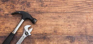 Hammer und Spannschlüssel auf Holz